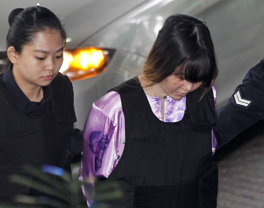 Vietnamese Doan Thi Huong, right, is escorted by police as she arrives for a court hearing at the Shah Alam court house in Shah Alam, outside Kuala Lumpur, Malaysia, Monday, Nov. 27, 2017. Huong and Indonesia Siti Aisyah are accused of killing Kim Jong Nam, the estranged half brother of North Korean leader Kim Jong Un. (AP Photo/Sadiq Asyraf)
