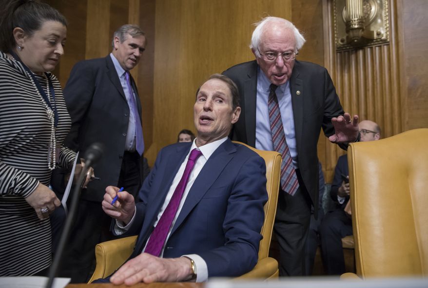 Sen. Ron Wyden, D-Ore., center, is flanked by Sen. Jeff Merkley, D-Ore., left rear, and Sen. Bernie Sanders, I-Vt., as the Senate Budget Committee met to work on the Republican tax bill, on Capitol Hill in Washington, Tuesday, Nov. 28, 2017. (AP Photo/J. Scott Applewhite)