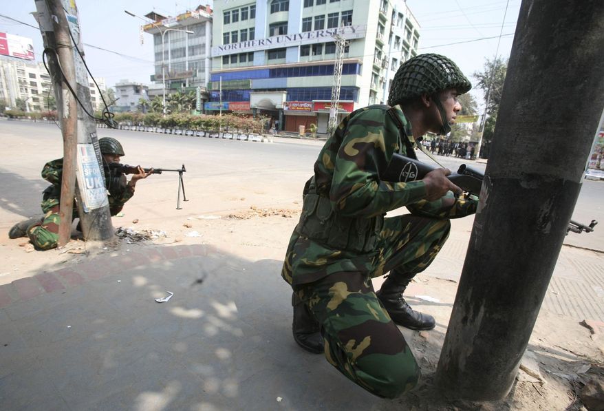 In this Feb. 25, 2009 file photo, Bangladesh army soldiers take positions near the headquarters of Bangladesh Rifles in Dhaka. In 2013, a trial court sentenced 152 people to death, but in response to an appeal, the High Court commuted the sentences for eight of them to life in prison and acquitted four others. Another man died during the 370 days of proceedings before Monday's verdict. A total of 846 people, mostly border guards, are facing trial. (AP Photo/Pavel Rahman, File)