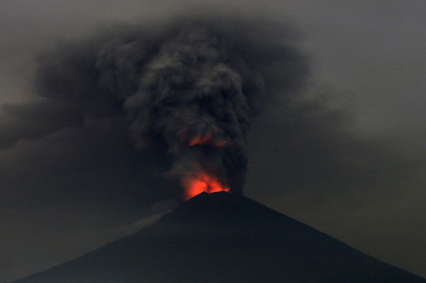 This Monday, Nov. 27, 2017, file photo, shows Mount Agung volcano erupting in Karangasem, Bali, Indonesia. Mount Agung volcano on Bali has erupted for the first time in more than half a century, forcing closure of the Indonesian tourist island's busy airport as the mountain gushes huge columns of ash that are a threat to airplanes. (AP Photo/Firdia Lisnawati, File)