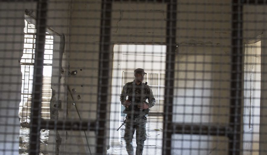A member of the U.S.-backed Syrian Democratic Forces (SDF) walk inside a prison built by Islamic State fighters at the stadium that was the site of IS fighters' last stand in the city of Raqqa, Syria, on Oct. 20, 2017. The SDF on Friday declared from the stadium during a ceremony the "total liberation" of Raqqa, the capital of the Islamic State for more than three years. (Associated Press) **FILE**
