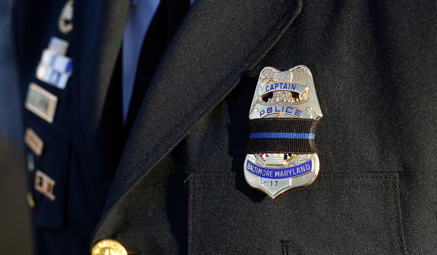 Baltimore Police Capt. Jarron Jackson wears a black mourning band across his badge before Baltimore Police Detective Sean Suiter's funeral at Mount Pleasant Church in Baltimore, Wednesday, Nov. 29, 2017. Suiter died a day after being shot while investigating a homicide case in a particularly troubled area of west Baltimore. (AP Photo/Patrick Semansky) ** FILE **