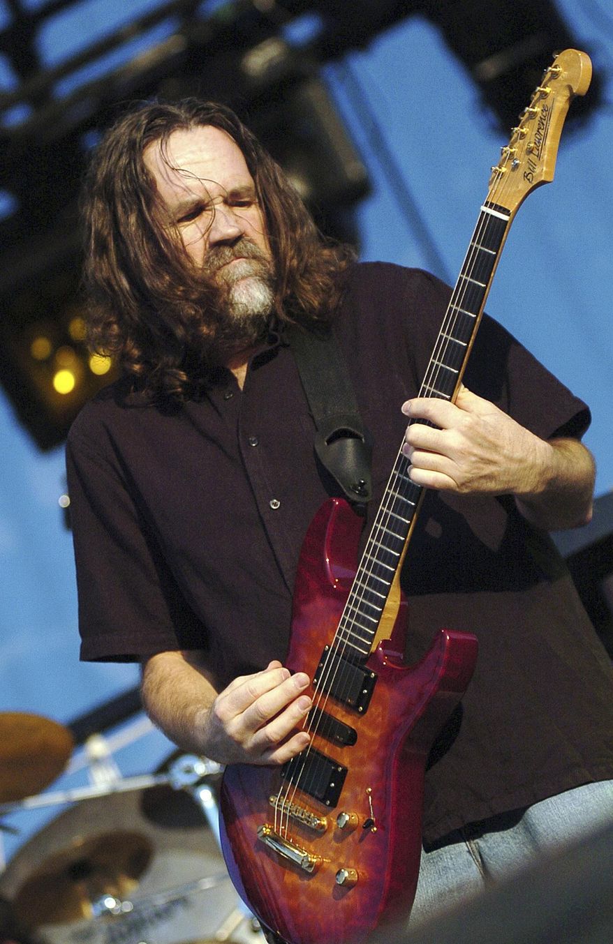 FILE - In this July 24, 2004 file photo, Boston lead singer and guitarist Brad Delp performs at the Outdoor Star Arena at Ameristar Casino and Hotel in Council Bluffs, Iowa. Fans of the rock band Boston can get more than a feeling at an upcoming auction - they can get their hands on the personal belongings of Delp. Delp’s concert grand piano, an electric guitar, silver glitter platform stage shoes and even his New Hampshire driver’s license are among the items for sale by Boston-based RR Auction starting Dec. 7, 2017. (Ben DeVries /The Daily Nonpareil via AP, File)