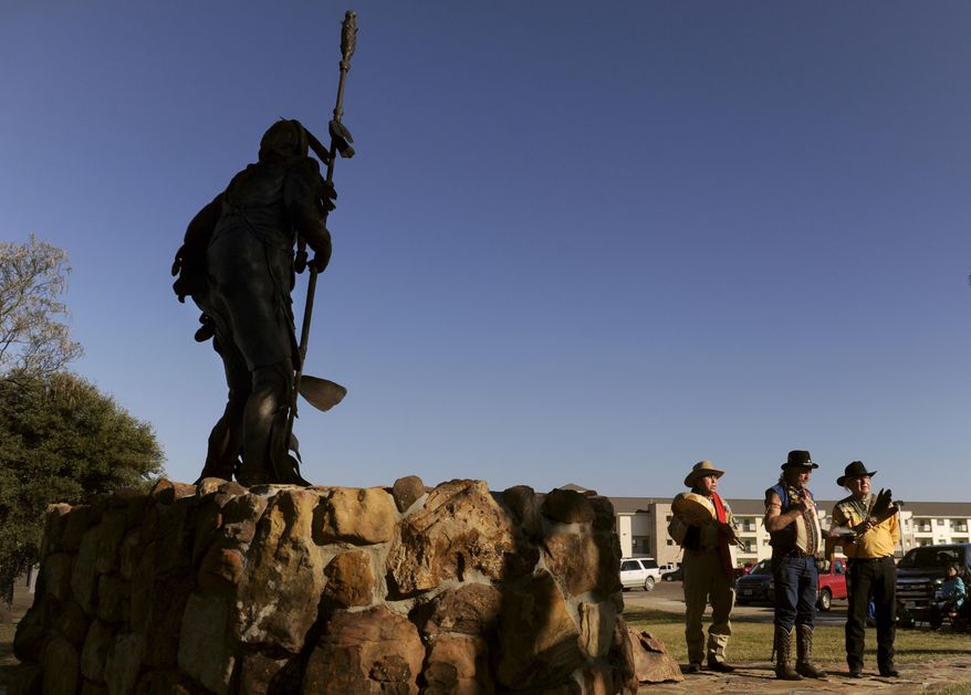 In a Nov. 16, 2017 photo, Don Parker, Paul Davis, and Bruce Parker face west as they begin a Comanche blessing of a statue of Quanah Parker at Western Texas College in Snyder, Texas. Both Parkers are descendants of Quanah who roamed the area 150 years ago. (W. Erdrich/The Abilene Reporter-News via AP)