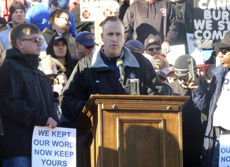 Joe Adams, a Grosse Pointe, Mich., police officer and president of the Michigan Fraternal Order of Police, speaks at a rally at the Michigan Capitol, Wednesday, Nov. 29, 2017, in Lansing, Mich. Police and firefighters are concerned that legislation, which has not been introduced but which is being drafted by Republican lawmakers, could lead to retiree health care cuts as part of efforts to address municipalities' unfunded liabilities. (AP Photo/David Eggert)