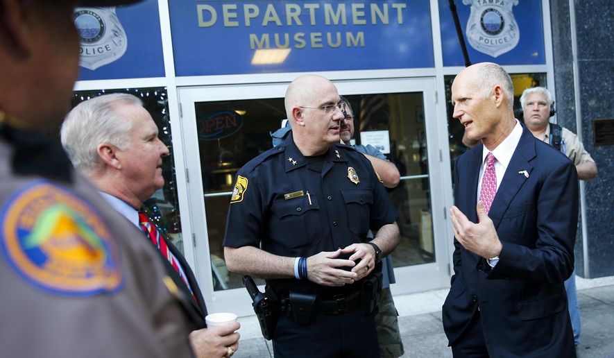 Florida Gov. Rick Scott, right, talks with Tampa Police Chief Brian Dugan, center, and Tampa Mayor Bob Buckhorn, left, outside Tampa Police Headquarters in Tampa, Fla. on Wednesday, Nov. 29, 2017. Scott&#39;s visit followed the announcement of the arrest in the Seminole Heights murders. (Will Vragovic/Tampa Bay Times via AP)