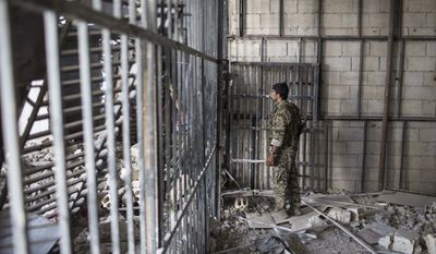 A members of the U.S.-backed Syrian Democratic Forces (SDF) walk inside a prison built by Islamic State fighters at the stadium that was the site of Islamic State fighters&#39; last stand in the city of Raqqa, Syria, Friday, Oct. 20, 2017. The SDF on Friday declared from the stadium during a ceremony the &quot;total liberation&quot; of Raqqa, the capital of the Islamic State for more than three years. (Photo/Asmaa Waguih)