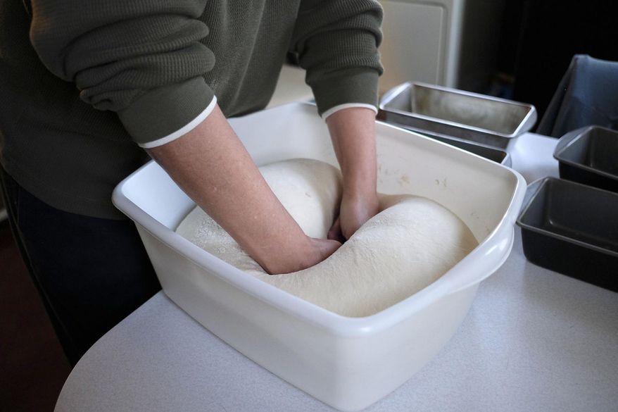 In this Nov. 20, 2017 photo, Paula Owen punches down bread, in her Steeleville, Ill., home. She had mixed the dough the night before using wild yeast that her family has kept alive for more than 100 years.This is the same bread recipe that Owen's mother used, and her mother before her. Owen said her mother would rub the tops of her loaves with bacon grease before they went into the oven, however she said she doesn't cook bacon enough to do that, which is why she uses margarine or butter. (Isaac Smith/The Southern, via AP)