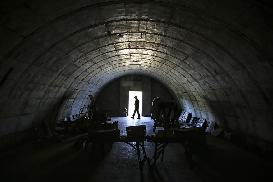 In this Nov. 8, 2017 photo, Drew Ullberg, supervisory natural resources manager at Midewin National Tallgrass Prairie, walks past the entrance to a Joliet Arsenal bunker in Wilmington, Ill. Preservationists are saving more than prairie at Midewin. Even many of the ammunition bunkers left behind from the Joliet Army Ammunition Plant days will be kept as the U.S. Forest Service that oversees Midewin tells a story of the transition of the land through history. (Eric Ginnard/Herald-News via AP)
