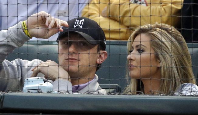 FILE - In this April 14, 2015, file photo, Cleveland Browns quarterback Johnny Manziel, left, sits with Colleen Crowley during a baseball game between the Los Angeles Angels and the Texas Rangers in Arlington, Texas. Prosecutors in Dallas have dismissed a 2016 misdemeanor domestic assault charge against Heisman Trophy-winning quarterback Johnny Manziel. The Dallas County District Attorney’s Office on Thursday, Nov. 30, 2017, confirmed Manziel successfully completed requirements of a court agreement that included taking an anger management course and participating in the NFL’s substance abuse program. The 24-year-old Manziel also had to stay away from Colleen Crowley, who accused him of hitting and threatening her during a January 2016 night out. (AP Photo/LM Otero, File)