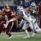 Washington Redskins quarterback Kirk Cousins (8) scrambles out of the pocket escaping pressure from Dallas Cowboys defensive end DeMarcus Lawrence in the first half of an NFL football game, Thursday, Nov. 30, 2017, in Arlington, Texas. (AP Photo/Ron Jenkins) ** FILE **