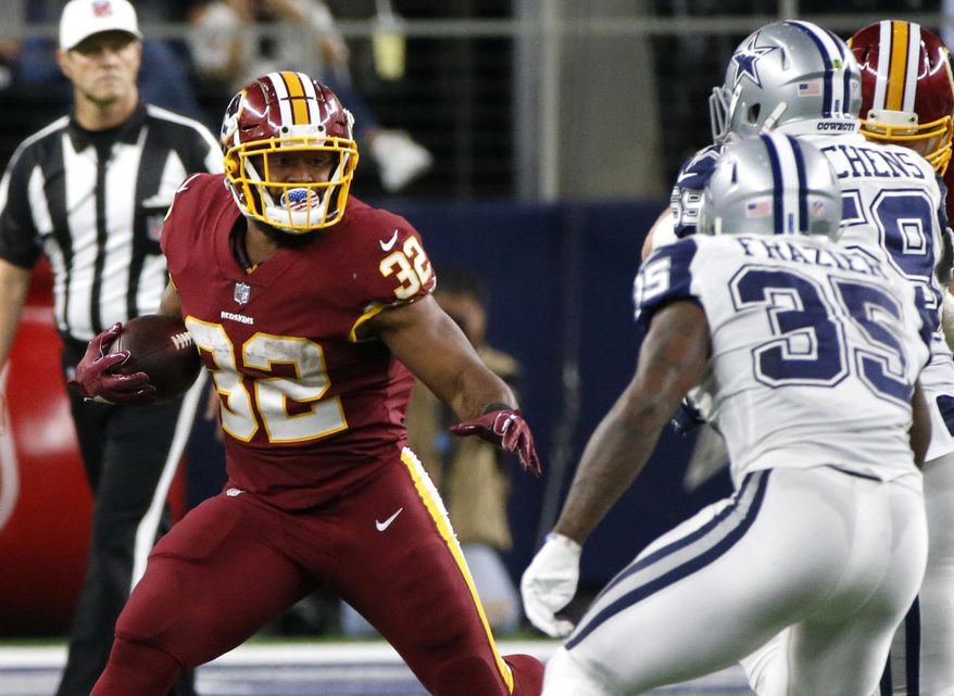 Washington Redskins running back Samaje Perine (32) carries the ball as Dallas Cowboys safety Kavon Frazier (35) and Anthony Hitchens, right rear, defend in the second half of an NFL football game, Thursday, Nov. 30, 2017, in Arlington, Texas. (AP Photo/Michael Ainsworth)
