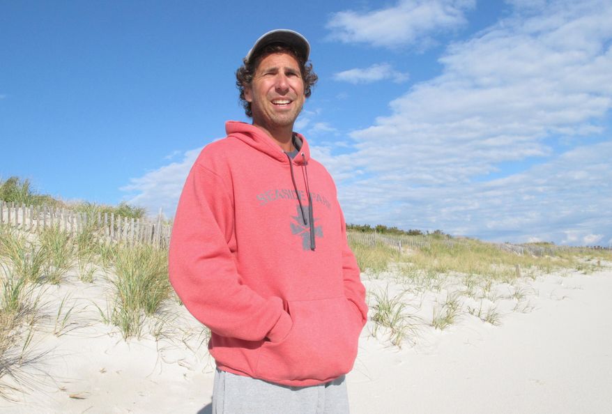 This Oct. 26, 2017 photo shows Dominick Solazzo, president of the Midway Beach Condominium Association on the beach in front of the 25-foot-tall dunes his members built and maintained over the decades in Berkeley Township, N.J. On Friday Dec. 1, 2017, a judge ruled that New Jersey can seize the beachfront land to make way for a shore protection project whose proposed dunes are smaller than what's already there. The state promised it would not shorten any dunes that are taller than those called for under its plan. (AP Photo/Wayne Parry)