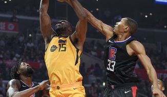 Los Angeles Clippers forward Wesley Johnson, right, blocks a shot by Utah Jazz forward Derrick Favors, center, as center DeAndre Jordan watches during the first half of an NBA basketball game in Los Angeles, Thursday, Nov. 30, 2017. (AP Photo/Kelvin Kuo)