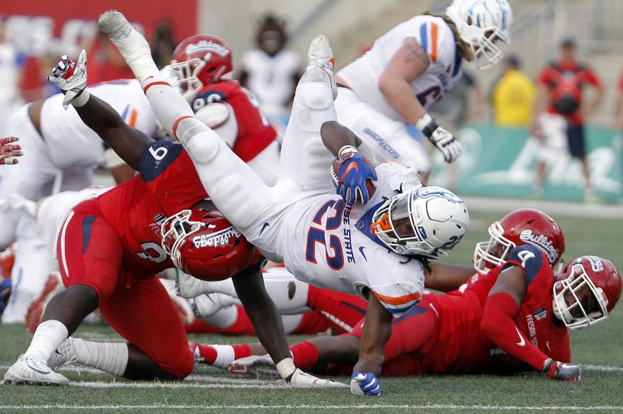 FILE - In this Saturday, Nov. 25, 2017, file photo, Fresno State's Jeffrey Allison upends Boise State's running back Alexander Mattison during the second half of an NCAA college football game in Fresno, Calif. For the second straight week Boise State and No. 25 Fresno State meet. This time it's for the Mountain West Conference championship and the game is in Boise rather than Fresno. (AP Photo/Gary Kazanjian, File)