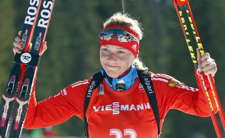 FILE - In this Sunday, March 9, 2014 file photo, Russia's Olga Zaitseva celebrates her third place in the women's 12.5km mass start at the biathlon World Cup competition in Pokljuka, Slovenia. The International Olympic Committee has disqualified three more Russian athletes from the 2014 Sochi Olympics for doping, including one of the country's greatest biathletes, it was reported on Friday, Dec. 1, 2017. (AP Photo/Darko Bandic, File)
