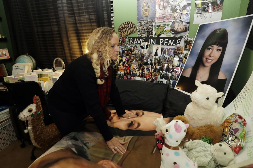 In this photo taken Tuesday, Nov. 28, 2017, Kimberly Gregory looks at a memorial for her daughter Michela, inside Michela's room, in South San Francisco, Calif. Michela died along with her boyfriend Alex Vega a year ago during a fire at the Ghost Ship warehouse in Oakland, Calif. The one-year anniversary of the deadliest building fire in the U.S. in more than a decade is bringing back painful memories for victims' families. It's also refocusing attention on Oakland, California, where the blaze occurred. Some critics say the beleaguered city hasn't moved quickly enough to prevent a similar tragedy. (AP Photo/Marcio Jose Sanchez)