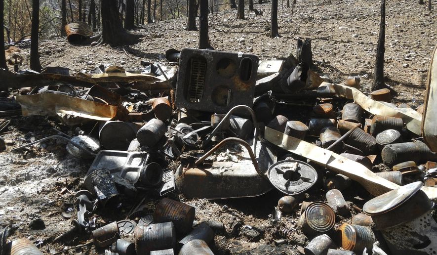 This undated photo provided by the Iron County Sheriff's Office shows the remnants of one of several burned out cabins built a Utah survivalist in the wilderness outside the ski resort town of Brian Head, Utah. The man's stockpiles of guns, grenades and food were discovered when a wildfire burned through the area this summer. (Iron County Sheriff's Office via AP)