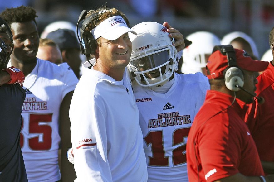 Florida Atlantic head coach Lane Kiffin hugs wide receiver John Franklin III (12) after he dropped the ball before crossing the goal line during the Conference USA championship NCAA college football game against North Texas, Saturday, Dec. 2, 2017, in Boca Raton, Fla. The play nullified a touchdown and resulted in a turnover. (Jim Rassol/South Florida Sun-Sentinel via AP)