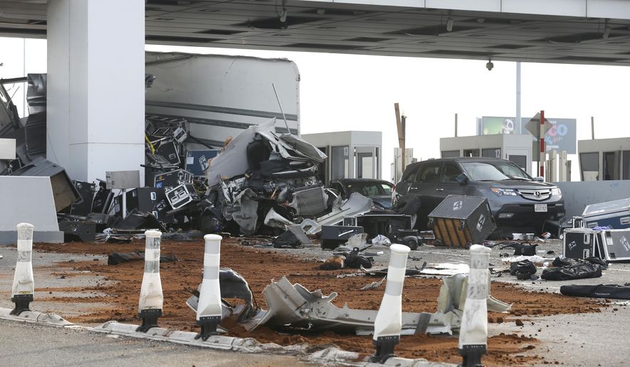Debris is spread across several westbound lanes at the Bay Bridge toll plaza after a truck rammed through a toll booth, killing the toll collector inside, before daybreak in Oakland, Calif. on Saturday, Dec. 2, 2017. The two occupants of the truck were reportedly ejected from the vehicle. (Paul Chinn/San Francisco Chronicle via AP)