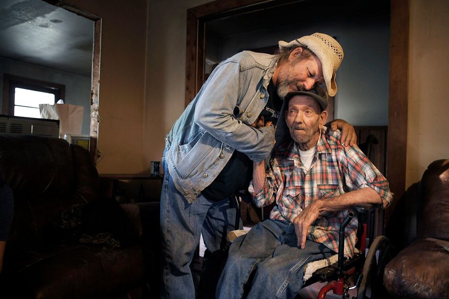 In this Saturday, Nov. 4, 2017 photo, Jack Stoddart embraces Willie Ray Abston, 78, who everyone knows as Cotton, in Crawford, Tenn. Abston has been in hospice three times, but continues to persevere. Stoddart, a man more well known as Hippie Jack, volunteers to delivered food to Abston. Stoddart has his mobile pantry outreach program that takes food and clothing to the needy in the ex-coal mining communities of Wilder, Cravenstown, and Vine Ridge. (Shelley Mays /The Tennessean via AP)