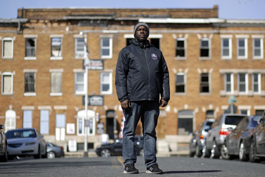 In this March 3, 2017 photo, community outreach worker Kelvin Parker poses for a portrait while walking in the Sandtown-Winchester neighborhood of Baltimore. Parker is one of three outreach workers at U-TURNS, a fledgling initiative with an ambitious goal: to reach teenagers and young adults in west Baltimore and provide an alternative to the streets. (AP Photo/Patrick Semansky)