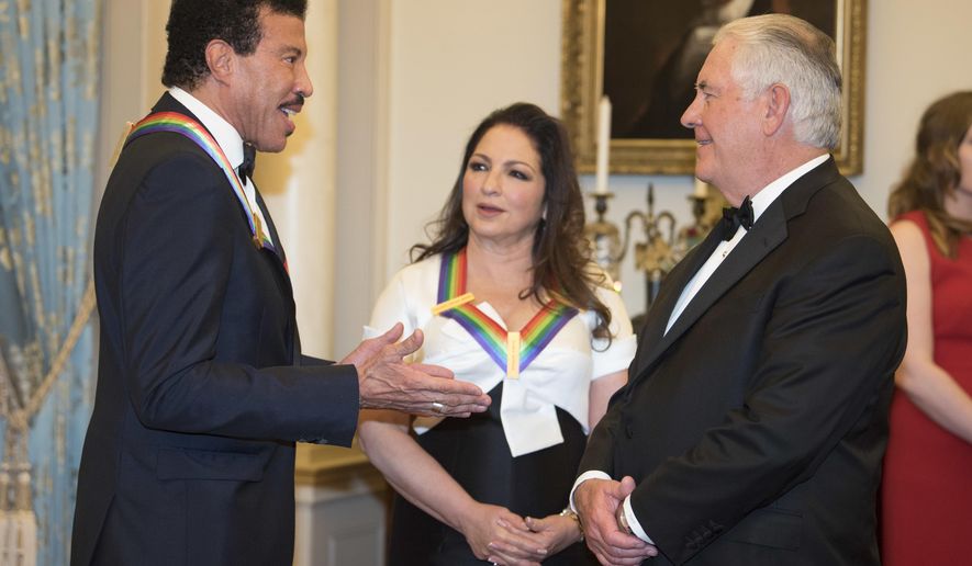 Secretary of State Rex Tillerson, right, talks with 2017 Kennedy Center Honorees Lionel Richie and Gloria Estefan, center, following the State Department dinner for the Kennedy Center Honors, Saturday, Dec. 2, 2017, in Washington. (AP Photo/Kevin Wolf)
