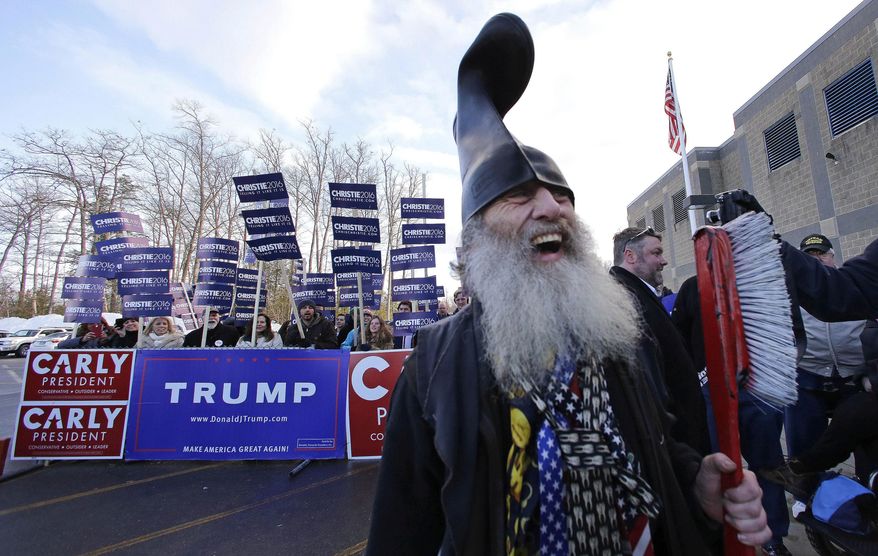 FILE - In this Tuesday, Feb. 9, 2016 file photo Democratic presidential candidate Vermin Supreme smiles while holding a giant toothbrush with a boot on his head while visiting a polling station on primary day during a campaign stop in Londonderry, N.H. Supreme, a humorous performance artist who is perennially on the ballot as a presidential candidate supporting laws mandating that people brush their teeth and in past presidential campaigns a promise to a free pony for every American. Supreme is suing the state capital, saying its denial of his request to bring two ponies to his planned protest of Hillary Clinton's book signing, scheduled for Tuesday, violates the First Amendment. (AP Photo/Charles Krupa)