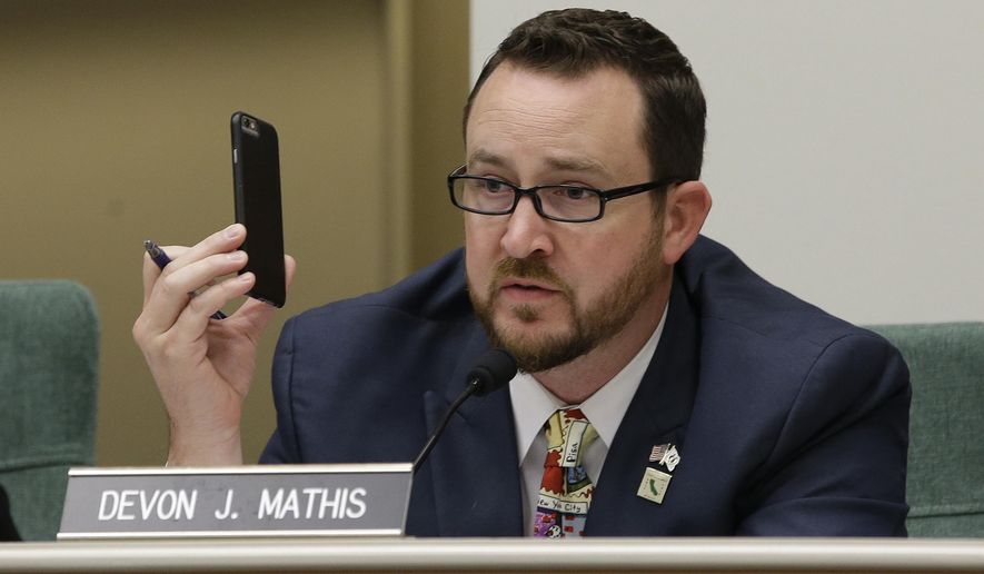 Assemblyman Devon Mathis, R-Visalia, holds up a cell phone as he questions Mark Ghilarducci, director of the California Office of Emergency Services, about their use in emergency situations, like the recent wildfires that swept through several Northern California counties in October, Monday, Dec. 4, 2017 in Sacramento, Calif. (AP Photo/Rich Pedroncelli)