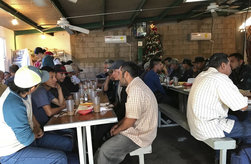 In this photo taken Monday, Dec. 4, 2017, some recently deported migrants eat breakfast at the dining room run by the nonprofit Kino Border Initiative in Nogales Mexico. The federal government on Tuesday, Dec. 5, 2017, issued its most complete statistical snapshot of immigration enforcement under President Donald Trump, saying Border Patrol arrests plunged to a 45-year low while arrests by deportation officers soared. (AP Photo/Anita Snow)