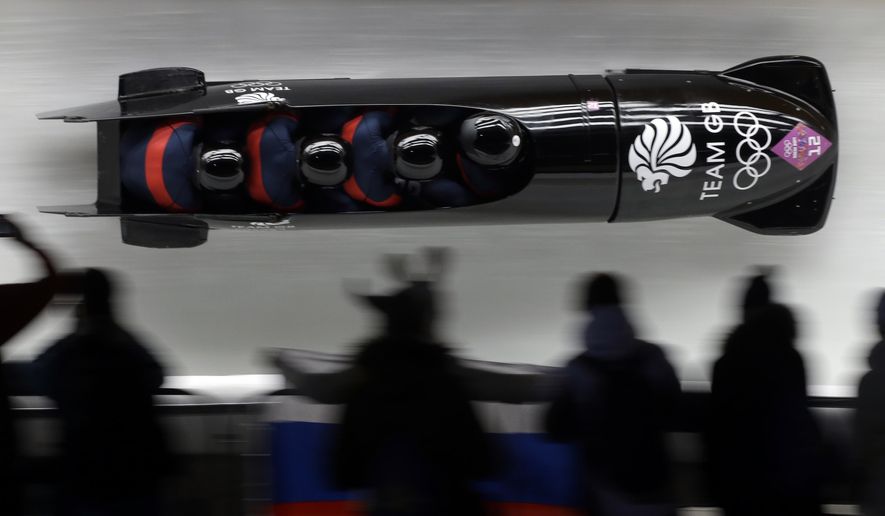 FILE - In this Feb.22, 2014 file photo, the team from Great Britain GBR-1, with John James Jackson, Stuart Benson, Bruce Tasker and Joel Fearon, take a curve on their first run during the men&#39;s four-man bobsled competition at the 2014 Winter Olympics, in Krasnaya Polyana, Russia. The British team, which placed fifth at the time, is now in line to get the bronze medal after two Russian sleds in front of them were disqualified for doping. The International Olympic Committee was deciding Tuesday whether to ban Russia from the 2018 Pyeongchang Games because of the doping scheme involving hundreds of athletes. (AP Photo/Dita Alangkara, File)