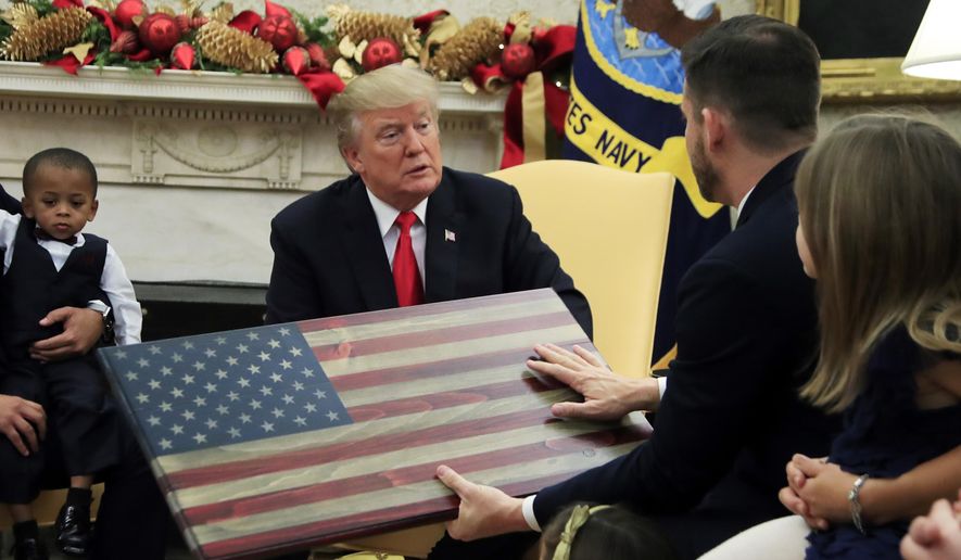 President Donald Trump is presented by Brian Steorts, owner of Flags of Valor, an American flag made of wood, during a meeting with American business owners and their families in the Oval Office at the White House in Washington, Tuesday, Dec. 5, 2017. (AP Photo/Manuel Balce Ceneta) ** FILE **