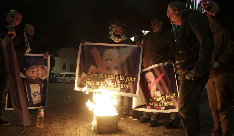 Palestinian burn a poster of the U.S. President Donald Trump during a protest in Bethlehem, West Bank, Tuesday, Dec. 6, 2017. President Trump forged ahead Tuesday with plans to recognize Jerusalem as Israel&#x27;s capital despite intense Arab, Muslim and European opposition to a move that would upend decades of U.S. policy and risk potentially violent protests. (AP Photo/Mahmoud Illean)