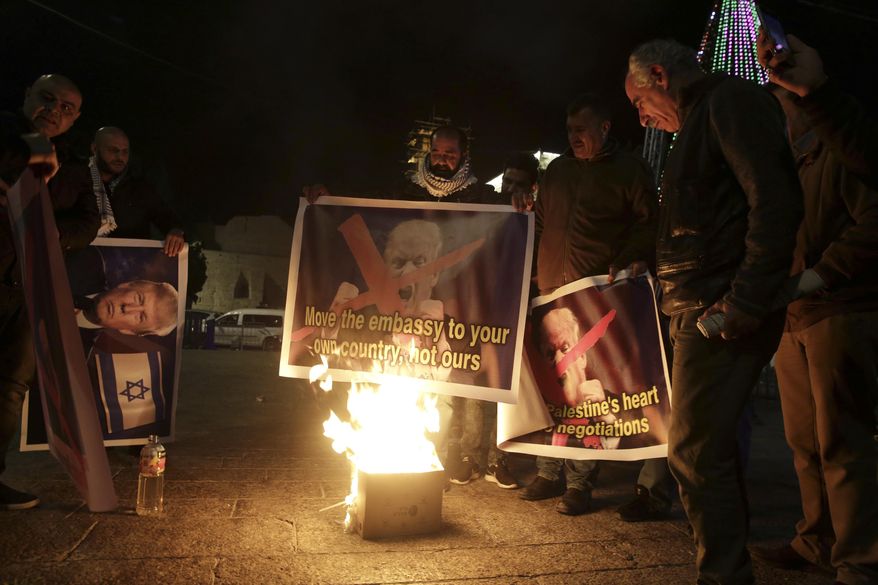 Palestinian burn a poster of the U.S. President Donald Trump during a protest in Bethlehem, West Bank, Tuesday, Dec. 6, 2017. President Trump forged ahead Tuesday with plans to recognize Jerusalem as Israel&#x27;s capital despite intense Arab, Muslim and European opposition to a move that would upend decades of U.S. policy and risk potentially violent protests. (AP Photo/Mahmoud Illean)