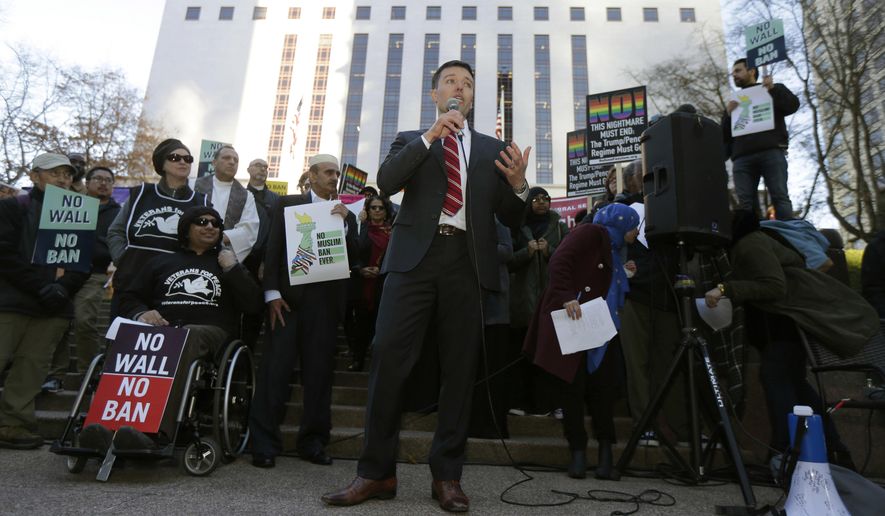 Washington Solicitor General Noah Purcell, center, speaks during a protest rally, Wednesday, Dec. 6, 2017, outside a federal courthouse in Seattle. The U.S. Supreme Court decision allowing President Donald Trump's third travel ban to take effect has intensified the attention on a legal showdown Wednesday before three judges in Seattle who have been cool to the policy as they hear arguments in Hawaii's challenge to the ban, which restricts travel to the United States by residents of six mostly Muslim countries and has been reviled by critics as discriminatory. (AP Photo/Ted S. Warren)