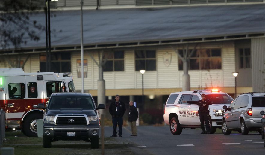 Officials direct traffic near Graham-Kapowsin High School, Tuesday, Dec. 5, 2017, in Graham, Wash. Authorities said two students were shot near the school Tuesday afternoon. (AP Photo/Ted S. Warren)