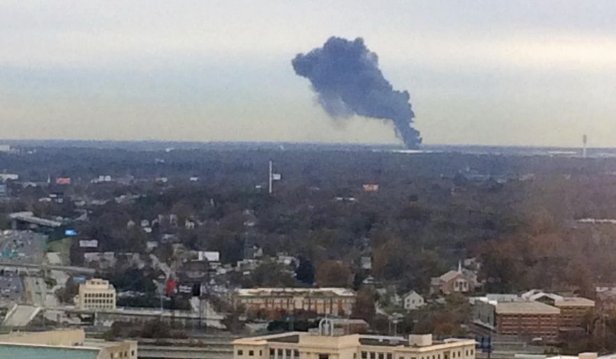 Smoke rises Hartsfield-Jackson Atlanta International Airport during a drill, Thursday, Dec. 7, 2017, in Atlanta. Authorities say a routine training exercise near the world's busiest airport in Atlanta produced a plume of heavy, dark smoke rising over the city and visible for miles. The airport is is the world's busiest, serving more than 104 million passengers annually.(AP Photo/Ron Harris)