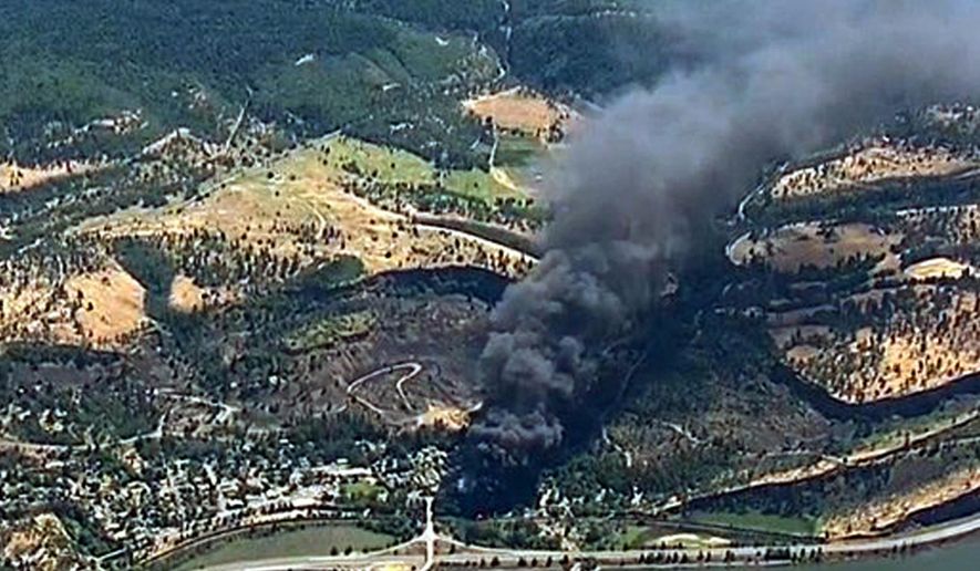 FILE- In this June 3, 2016, file image, from video provided by KGW-TV, smoke billows from a Union Pacific train that derailed near Mosier, Ore., in the scenic Columbia River Gorge. The Trump administration is angering environmental groups and residents of the Columbia River Gorge by rolling back a 2015 rule on oil train safety. (KGW-TV via AP, File)