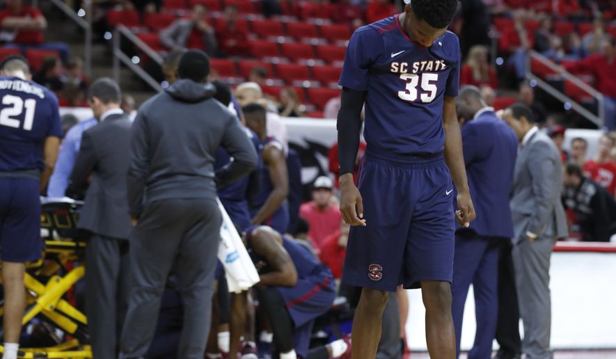 FILE - In this Dec. 2, 2017, file photo, South Carolina State players, including Damani Applewhite (35), react as Tyvoris Solomon is attended to after he was injured during the first half of an NCAA college basketball game against North Carolina State in Raleigh, N.C. Solomon, who collapsed on the court during the game last week, has been released from the hospital. (Ethan Hyman/The News & Observer via AP, File)