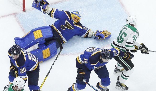 St. Louis Blues goalie Jake Allen, top left, falls while reaching for a puck as Dallas Stars&#x27; Gemel Smith (46) watches during the first period of an NHL hockey game Thursday, Dec. 7, 2017, in St. Louis. (AP Photo/Jeff Roberson)