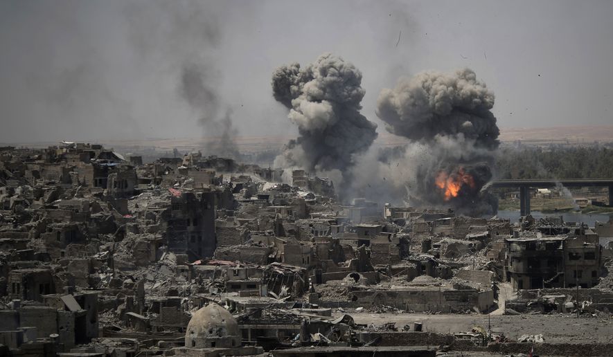 In this July 11, 2017, file photo, airstrikes target Islamic State positions on the edge of the Old City in Mosul, Iraq. Iraq said Saturday, Dec. 9, 2017, that its war on the Islamic State is over after more than three years of combat operations drove the extremists from all of the territory they once held. Prime Minister Haider al-Abadi announced Iraqi forces were in full control of the country's border with Syria. (AP Photo/Felipe Dana, File)