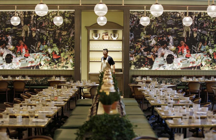 In this Dec. 6, 2017 photo, an employee walks through Primrose, a new restaurant at the Monte Carlo hotel and casino in Las Vegas. The Monte Carlo is undergoing renovations to become the Park MGM. (AP Photo/John Locher)
