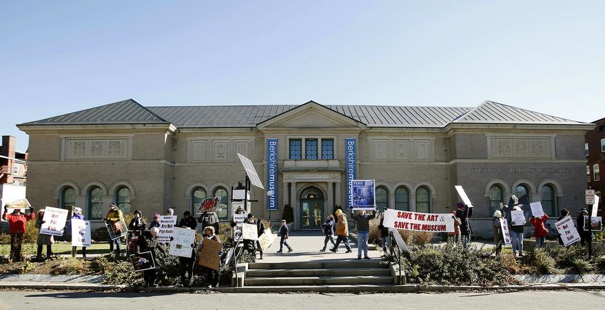 FILE - In this Nov. 11, 2017 file photo, some 30 protesters gather outside of the Berkshire Museum in Pittsfield, Mass., holding signs bearing pleas to "save the art" and thanking Attorney General Maura Healey for her office's last minute appeals court filing that was successful in delaying the first sale of 40 works of art, including two by Norman Rockwell. The intensifying legal tussle over whether the museum should be allowed to auction the 40 works of art has raised questions about when, if ever, it's appropriate to unload the collection. (Stephanie Zollshan/The Berkshire Eagle via AP, File)