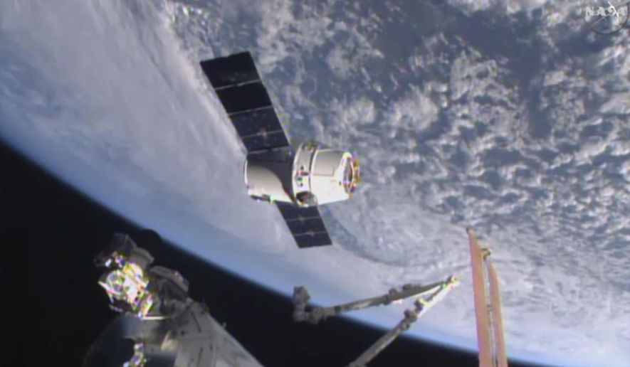 FILE - In this April 17, 2015, file image from NASA-TV, the SpaceX Dragon 6 resupply capsule nears the International Space Station. The capsule will be making a return trip to the space station when it is launched on a recycled rocket for NASA on Tuesday, Dec. 12, 2017. (NASA-TV via AP, File)