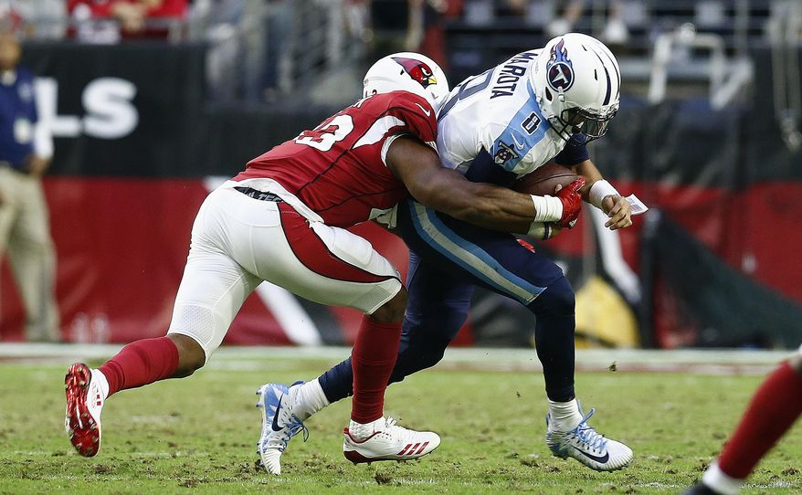 Arizona Cardinals inside linebacker Haason Reddick, left, brings down Tennessee Titans quarterback Marcus Mariota (8) during the second half of an NFL football game Sunday, Dec. 10, 2017, in Glendale, Ariz. The Cardinals defeated the Titans 12-7. (AP Photo/Ralph Freso)