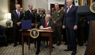 President Donald Trump signs the National Defense Authorization Act for Fiscal Year 2018, in the Roosevelt Room of the White House, Tuesday, Dec. 12, 2017, in Washington. (AP Photo/Evan Vucci)