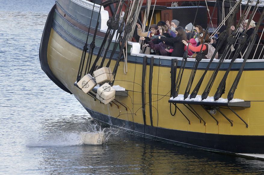 In this Monday, Dec. 11, 2017 photo, visitors to the Boston Tea Party Museum throw replicas of historic tea containers into Boston Harbor from aboard a replica of the vessel Beaver, in Boston. The museum is encouraging Americans to send unused tea leaves to toss into Boston Harbor as part of the Saturday, Dec. 16, 2017, annual re-enactment of the historic act of defiance that led to the Revolutionary War. (AP Photo/Steven Senne)