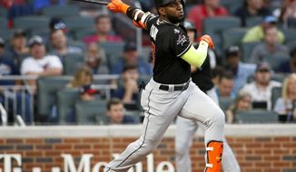 FILE - In this Sept. 7, 2017, file photo, Miami Marlins&#39; Marcell Ozuna watches his RBI triple during the first inning of a baseball game against the Atlanta Braves, in Atlanta. A person familiar with the negotiations says Miami has agreed to trade left fielder Marcell Ozuna to the St. Louis Cardinals, the third All-Star jettisoned by the Marlins this month in an unrelenting payroll purge under new CEO Derek Jeter. The person spoke to The Associated Press on condition of anonymity Wednesday because the agreement had not been announced and was subject to a physical. (AP Photo/Brett Davis, File)