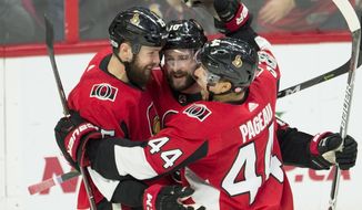Ottawa Senators left wing Zack Smith, left, celebrates his goal with left wing Tom Pyatt and centre Jean-Gabriel Pageau, right, celebrate a goal during third period NHL action in Ottawa on Wednesday, Dec. 13, 2017. (Adrian Wyld/The Canadian Press via AP)