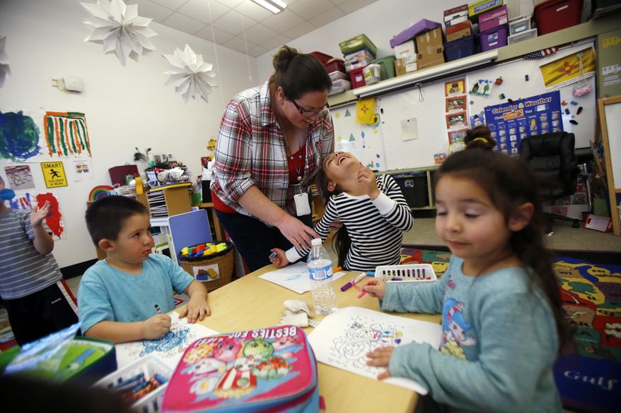 In this Thursday, Dec. 7, 2017 photo, Natasha Juarez, a preschool teaching assistant at Turquoise Trail Charter School in Santa Fe, N.M., helps Kaia Ortiz, 4. "I just love working with these kids," says Juarez. "If it (a shooting) happens, I'm not even gonna worry about myself. I'm gonna worry about the little kids and do what I have to do to get them safe," she said. (Luis Sánchez Saturno/Santa Fe New Mexican via AP)